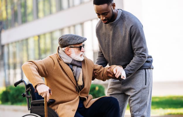 man-helping-senior-disabled-man | 4 Surefire Ways for How To Deal With Caregiver Guilt And Other Caregiving Emotions