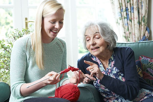 Grandmother-Showing-Granddaughter-How-To-Knit | Senior Conversation Starters: 6 Topics To Talk About With Your Elderly Relatives