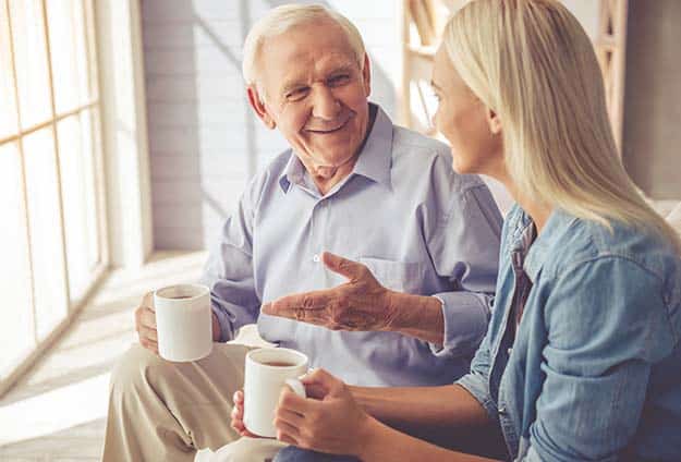 Handsome-old-man-and-beautiful-young-girl-are-drinking-tea | Senior Conversation Starters: 6 Topics To Talk About With Your Elderly Relatives