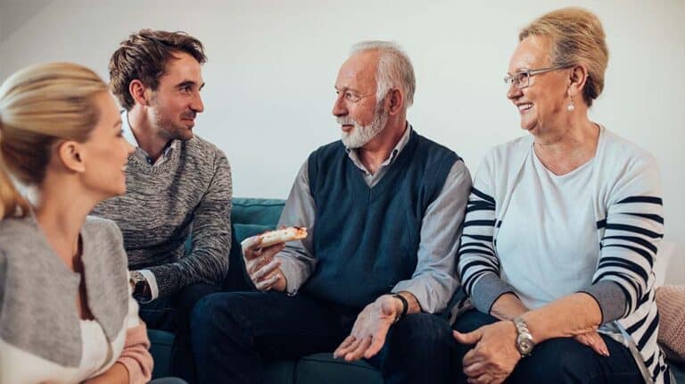 Young-couple-talking-with-parents-Senior-Conversation-Starters | Senior Conversation Starters: 6 Topics To Talk About With Your Elderly Relatives