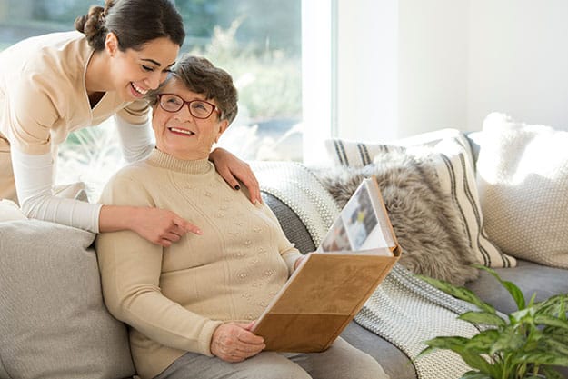 Grandmother-sitting-on-a-couch-in-a-sunny-room | Why Social Interactions Are Important To Keep Your Parents Healthy