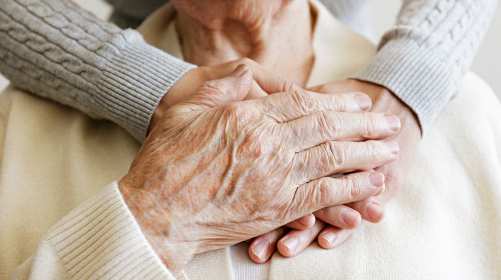 BLOG_12O_aged-wrinkled-skin-&-hands-of-her-care-giver_Are-You-A-Family-Caregiver | feature | 6 Issues Families Face with Caregivers and How To Handle Them
