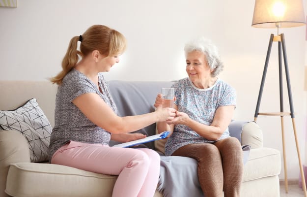 Caregiver-giving-glass-of-water-to-senior-woman_Arrange-In-Home-Care_ss_body | 5 Genius Tips For Effective and Efficient Long-Distance Caregiving