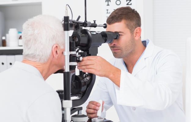 Male-optometrist-examining-senior-mans-eyes_Eye-Exam_ss_body | 9 Recommended Preventive Health Care Screenings For Seniors