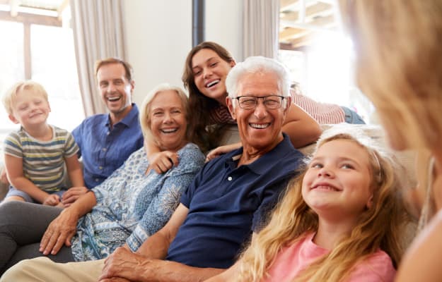 Multi-Generation-Family-Sitting-On-Sofa_Sharing-Re…onsibilities-with-Other-Family-Members_ss_body | 5 Genius Tips For Effective and Efficient Long-Distance Caregiving