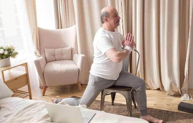 senior-man-doing-yoga-with-chair_Chair-Yoga-for-Seniors_ss_body| 5 Amazing Benefits Of Yoga For Seniors & How To Get Started