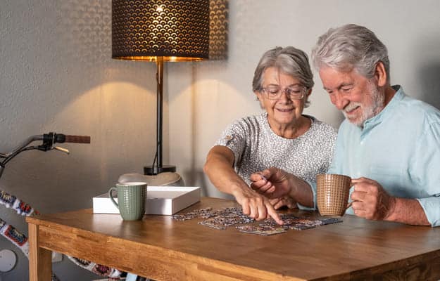 smiling-senior-couple-doing-jigsaw-puzzle 8 Memory Board Games Perfect For Your Beloved Family Members body ss.