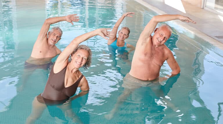 12Oak Group of seniors exercising their backs at aquafitness course in the pool by a swimming pool 5 Reasons Why Swimming Is a Great Exercise For Seniors