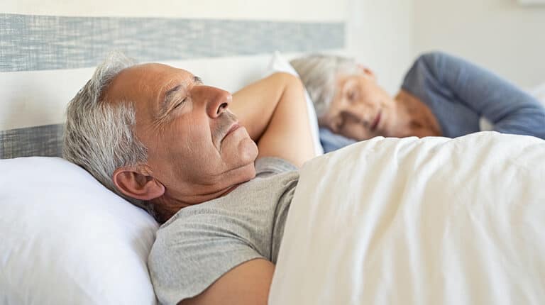 12Oaks-Senior man and woman sleeping on bed-ss-Best Sleep Positions For Seniors-Feature