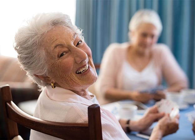 12Oaks-smiling-senior-woman-playing-cards-friends-ss-Why Should Your Elder Family Members Choose Recreational Therapy
