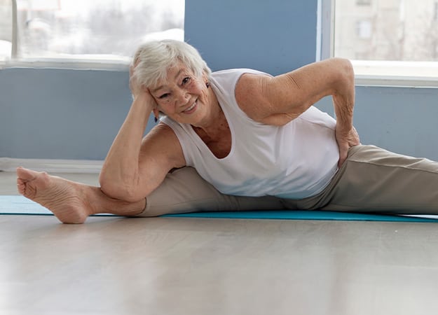 12Oaks A happy positive elderly woman does splits and yoga exercises ss 3.Yoga