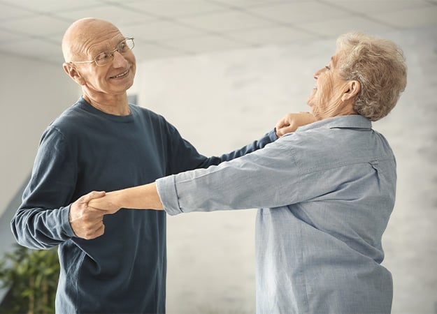 12Oaks-Cute elderly couple dancing at home-as-4 Music Activities You and Your Seniors Will Enjoy Doing