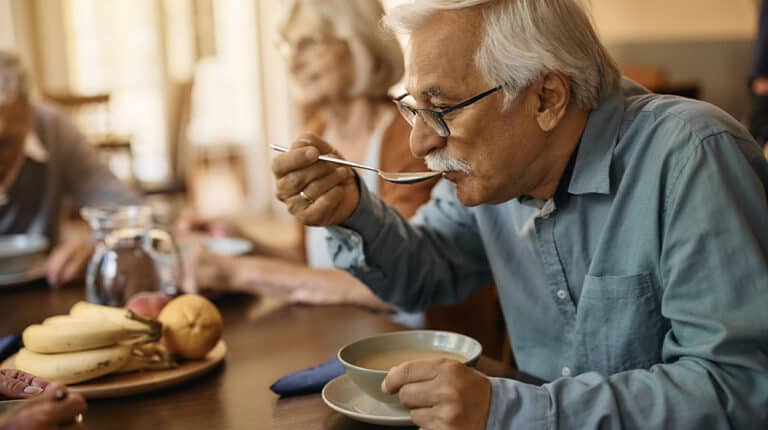 12Oaks-Senior man eats soup while having lunch at residential care home-as-5 Flavorful Cold Weather Food Ideas Your Elder Family Members Will Enjoy-Feature