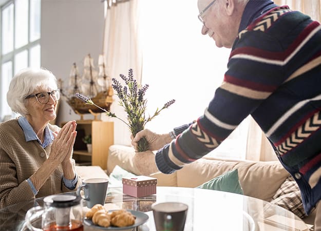 12Oaks-Warm toned portrait of happy senior man giving present-as-Senior Dating-Dating Advice for Seniors