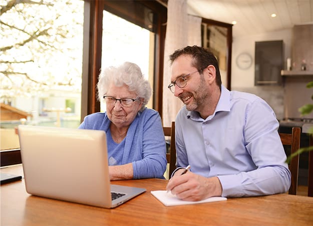 12Oaks-mature man helping elderly senior woman at home with computer-as-2. Go For Trusted Sites