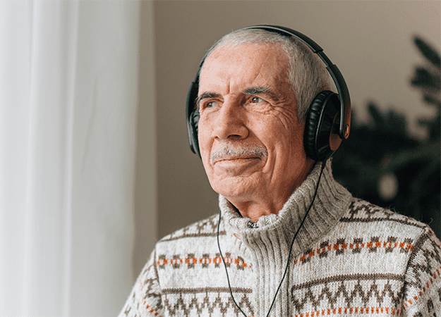 12Oaks-Senior man listening music in headphones-ss-Carrying Out Music Therapy