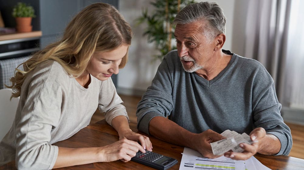 12Oaks-Senior man with adult daughter looking for solution in financial problem-as-What to Consider When Setting Budget Plans for Your Elderly Loved Ones-Feature