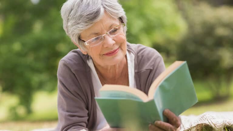 Senior woman reading a book at park-as-7 Inspiring Books Our Parents Will Enjoy-Feature