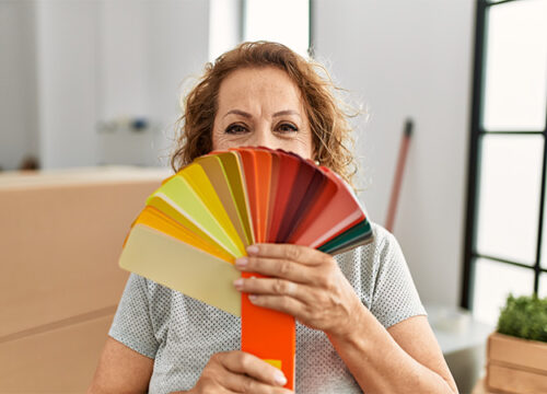 12Oaks-Middle age caucasian woman covering mouth with color paint test at new home-as-4 Color Matters