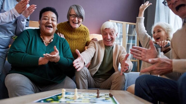 12Oaks-Multiethnic group of excited senior people playing board games at retirement home and celebrating win-as-9 Fun Activities Elderly People Should Do to Avoid Memory Loss-Feature