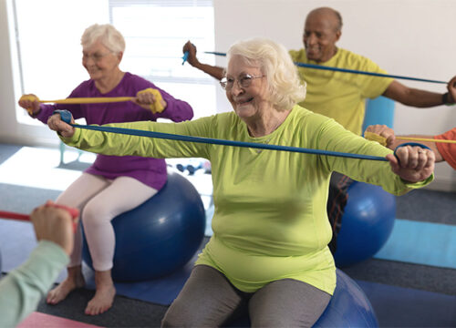 12Oaks-Senior people exercising with resistance band in fitness studio-as-What is Assisted Living _ What Services Does It Provide_