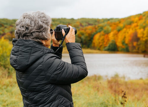 12Oaks-retirement hobby concept. Back view senior woman takes photo on digital camera-as-3 Photography Clubs