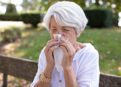 12Oaks-senior woman with tissue having flu or allergy at park-as-1 Beware of Seasonal Allergies