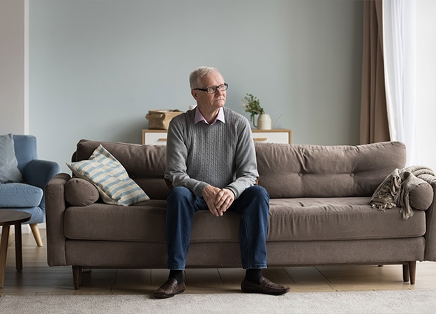 12Oaks-Serious thoughtful old pensioner man sitting on home couch-as-Estate Planning For Seniors- Why Is It Important_