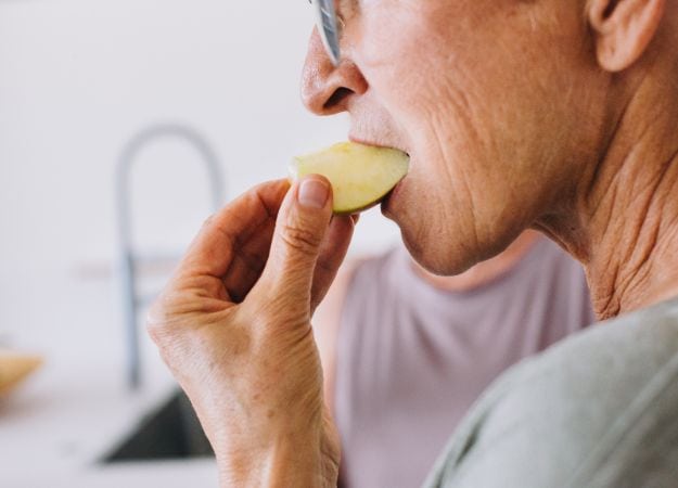 12Oaks-Elderly woman eating apple-canva-1 Malnourishment