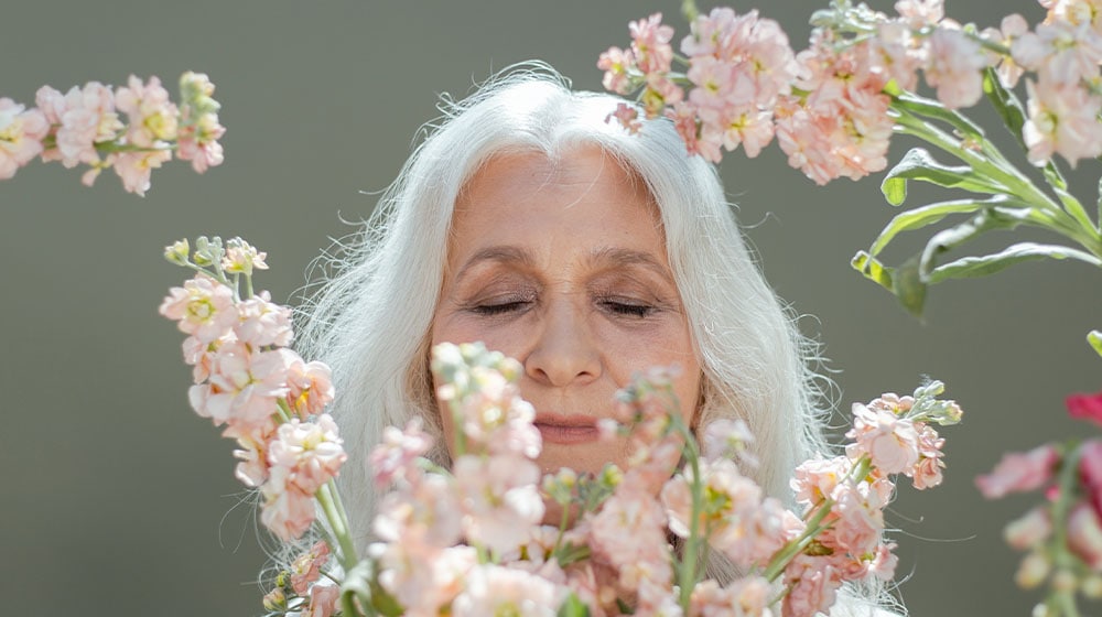 12Oaks-Senior-woman-surrounded-by-flowers-pexels-The-Advantage-of-Aromatherapy-for-Parents-with-Dementia