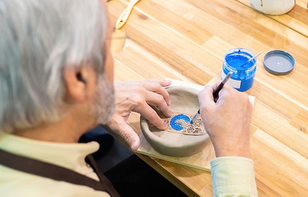 A-Man-Painting-a-Ceramic-Bowl---Fall-Craft-and-Creative-Arts-Activities---px-body