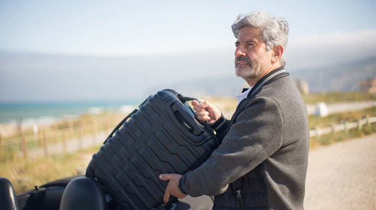 Man-in-Gray-Jacket-Holding-a-Suitcase---Travel-Tips-for-Seniors-Exploring-the-World-in-Their-Golden-Years---px-feat