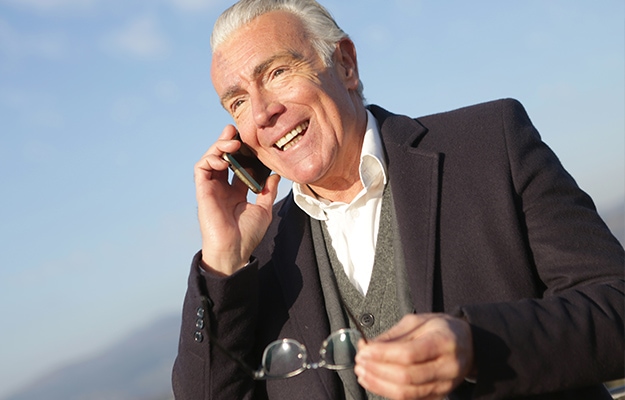 Mature-businessman-having-conversation-on-smartphone-in-city---Senior-Travel-Tip-#4-Consider-an-International-Phone-Plan---px-body