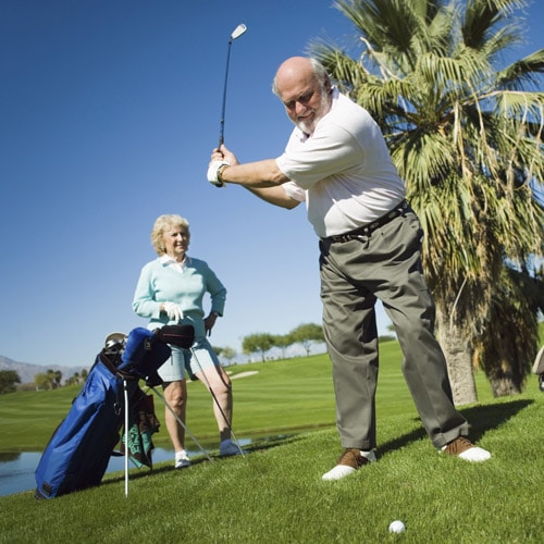 senior couple playing golf