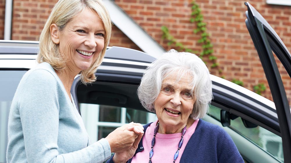 senior-woman-holding-hand-of-adult-daughter-in-front-of-car-Driving-Safety-Tips-for-Seniors