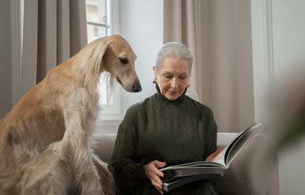 12Oaks-Elderly woman reading the book to her dog-cnv-2 Pets Relieve Feelings of Loneliness in Seniors