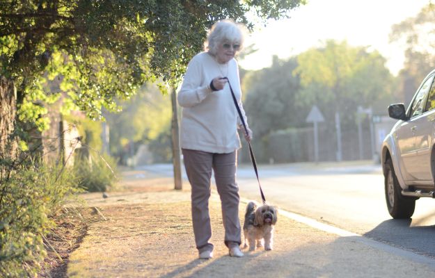 12Oaks-Elderly woman walking with her dog-cnv-1 Pets Keeps Seniors Active