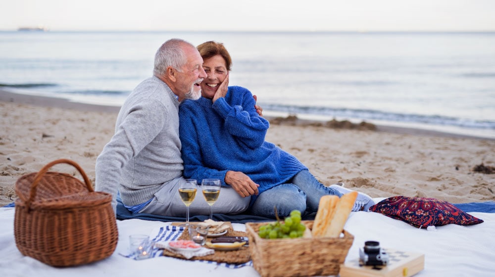Happy-Seniors-enjoying-meal-at-the-beach_The-Role-of-Nature-Outdoor-Spaces-in-Assisted-Living-Communities