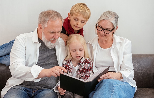 12Oaks-Grandparents looking photo album with their grandchildren-pxls-2 Strengthen Family Connections