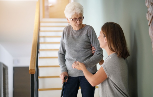 helping-elderly-woman-going-down-the-stairs_How-To-Organize-and-Declutter_5-Relocate-To-The-First-Floor_as_body