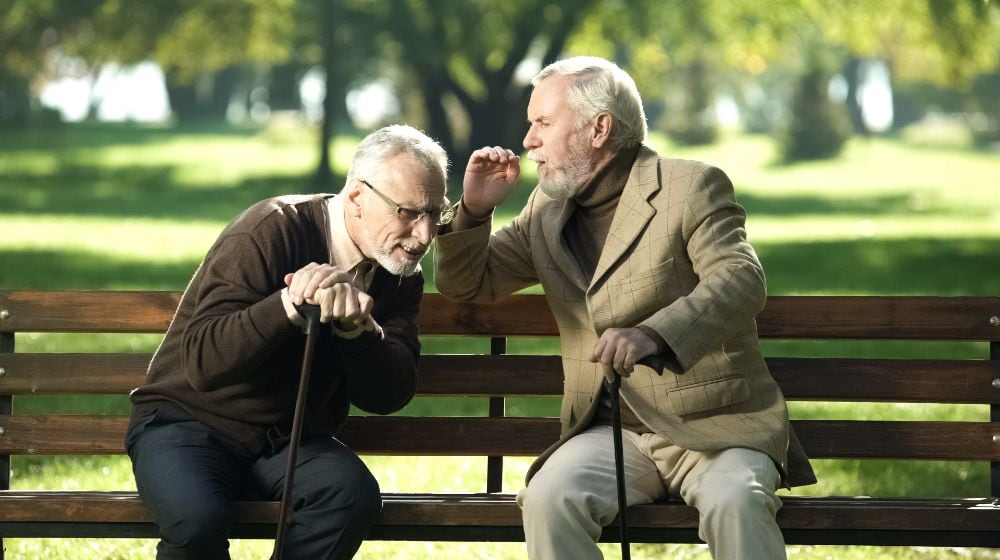 Senior gentlemen talking to his hearing impairment old friend, health problems