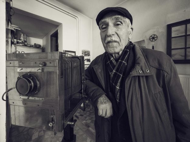 Portrait of a Senior Photographer Posing beside an Old-Fashioned Camera pexels