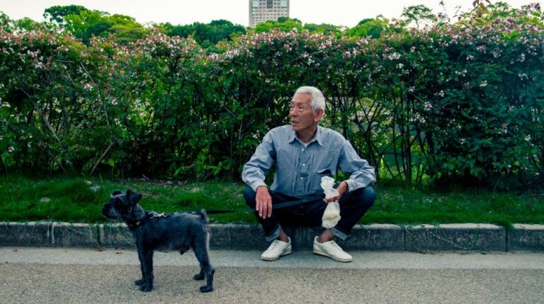 Elderly Man Sitting on Curb While Holding Dog on Leash | celebration of life quotes px featured image