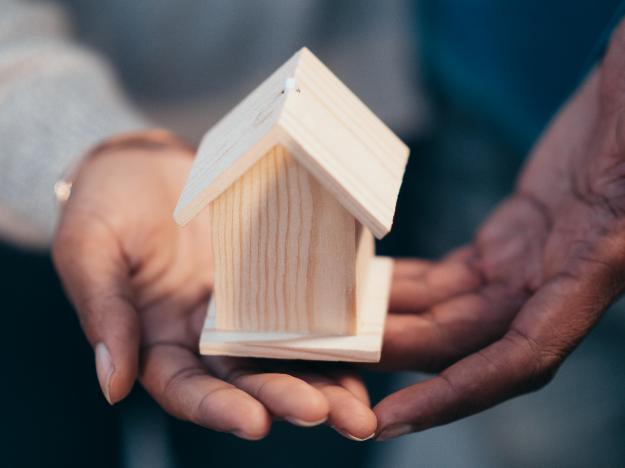 Person Holding Miniature Wooden House px (1)