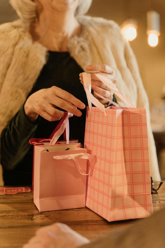 Hands of a Woman Holding Pink Paper Bags | Black Friday safety for seniors px