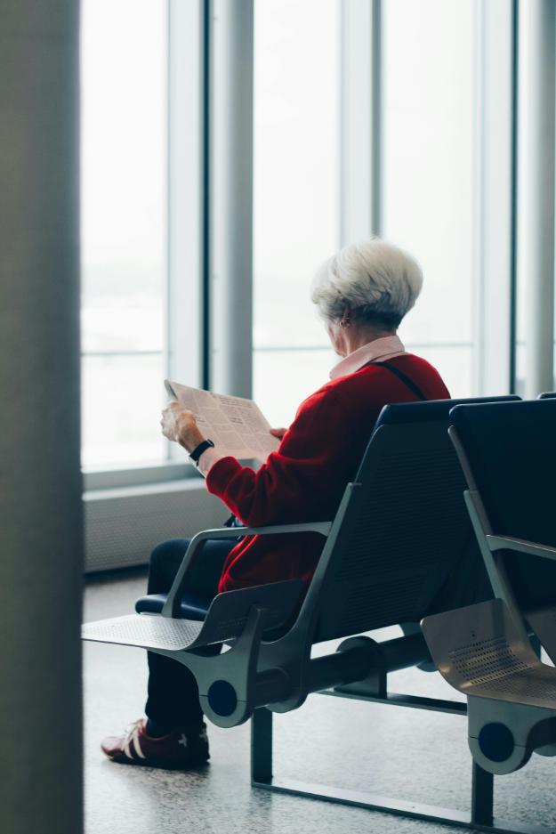 Person In Red Coat Sitting On Chair _ thanksgiving travel tips for seniors px